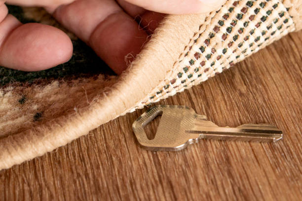 istock A man raises a key hidden under a mat 1190669782