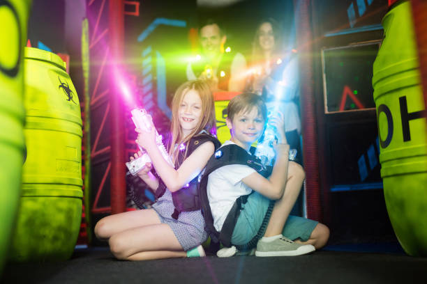istock Kids sitting back to back on beams with laser pistols 1190669848