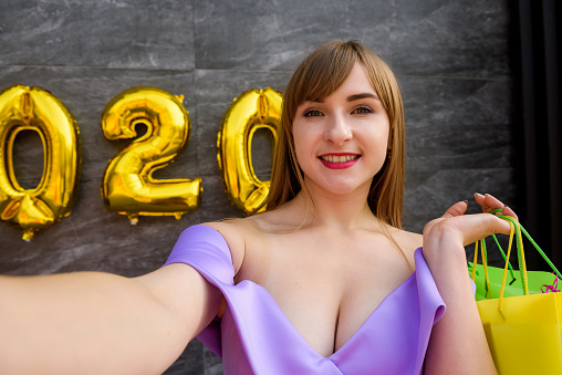 Studio portrait of beautiful women with golden numbers air balloons . Happy New Year 2020 holiday party concept