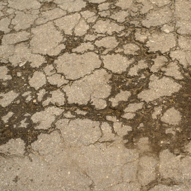 istock Closeup top view of cracked broken grey concrete road. 1190677598