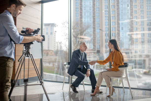 istock Team of reporters working on a interview with a grey-haired man 1190684845