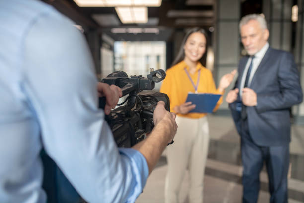 istock Asian female reporter in beige pants smiling nicely 1190684880