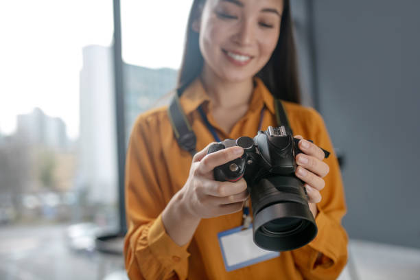 istock Dark-haired young cute reporter checking photos in camera 1190685043