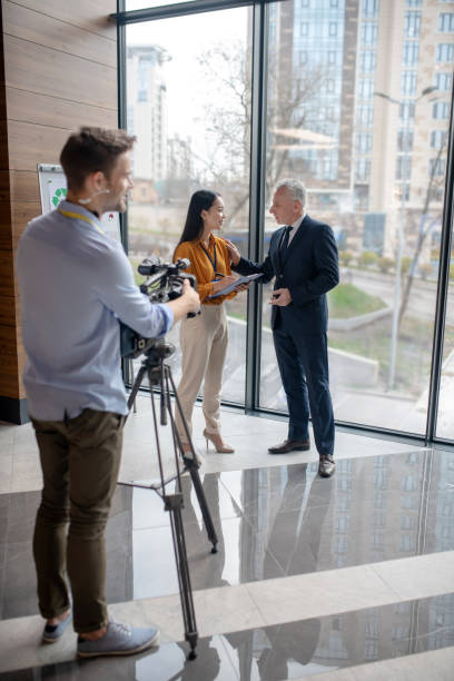 istock Young asian reporter talking to a grey-haired man 1190685123