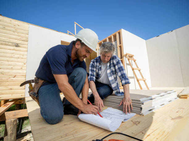 istock Mature architect talking to contractor at the construction site while checking blueprint 1190692082