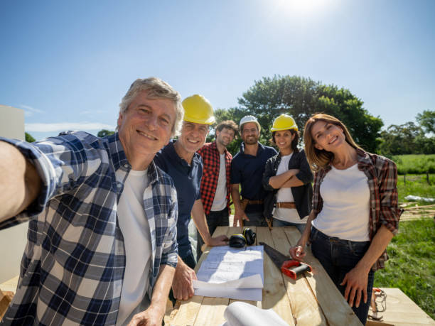 Senior male contractor taking a selfie with his team at the construction site