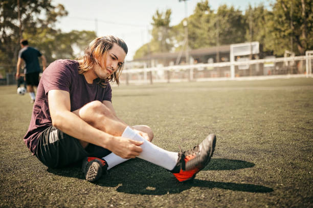 istock Young player sitting on grass before soccer match 1190693907