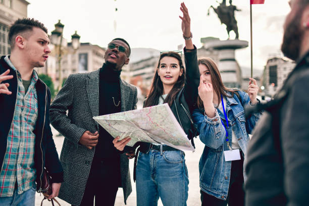 istock Female Guide Explaining The Way To Tourists According To Map 1190694112