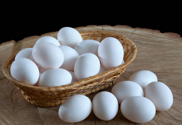 istock Chicken eggs in a basket on a wooden background 1190698236