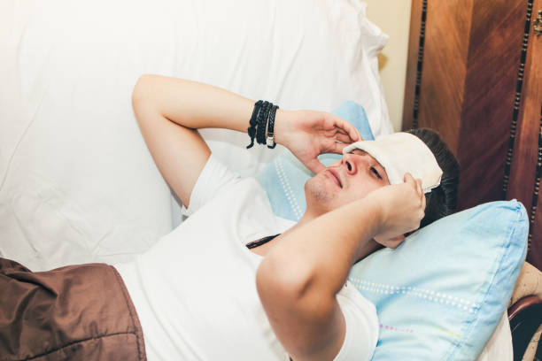 istock Man with a cold lying in sofa stock photo 1190699855