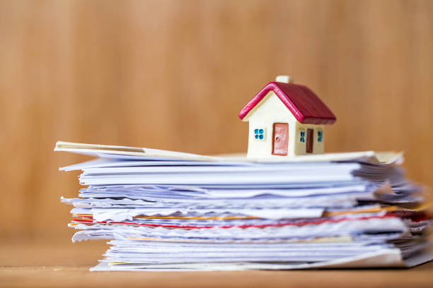 istock house on stack of paper over wooden mock up background 1190701103