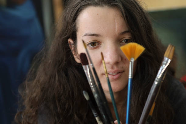 istock Girl with various paintbrushes 1190707643