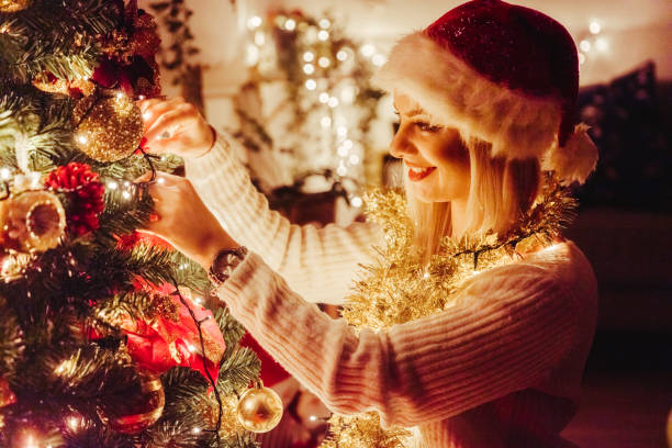 istock Smiling woman in a white sweater over Christmas tree. 1190714834