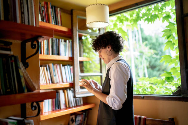 Woman texting in front of a bookshelf