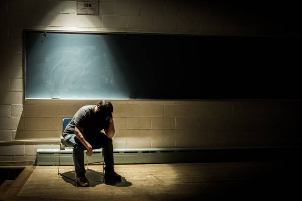 istock Stressed Man in a Dark, Moody Classroom 1190717158