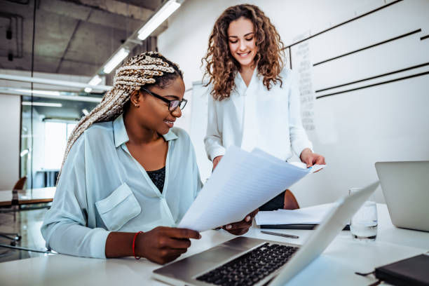 istock Two young women work together in a bright office. Work on the project, consultation. 1190733411