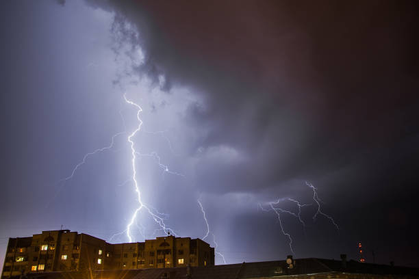 istock Bright lightning in the black sky over the city 1190734423
