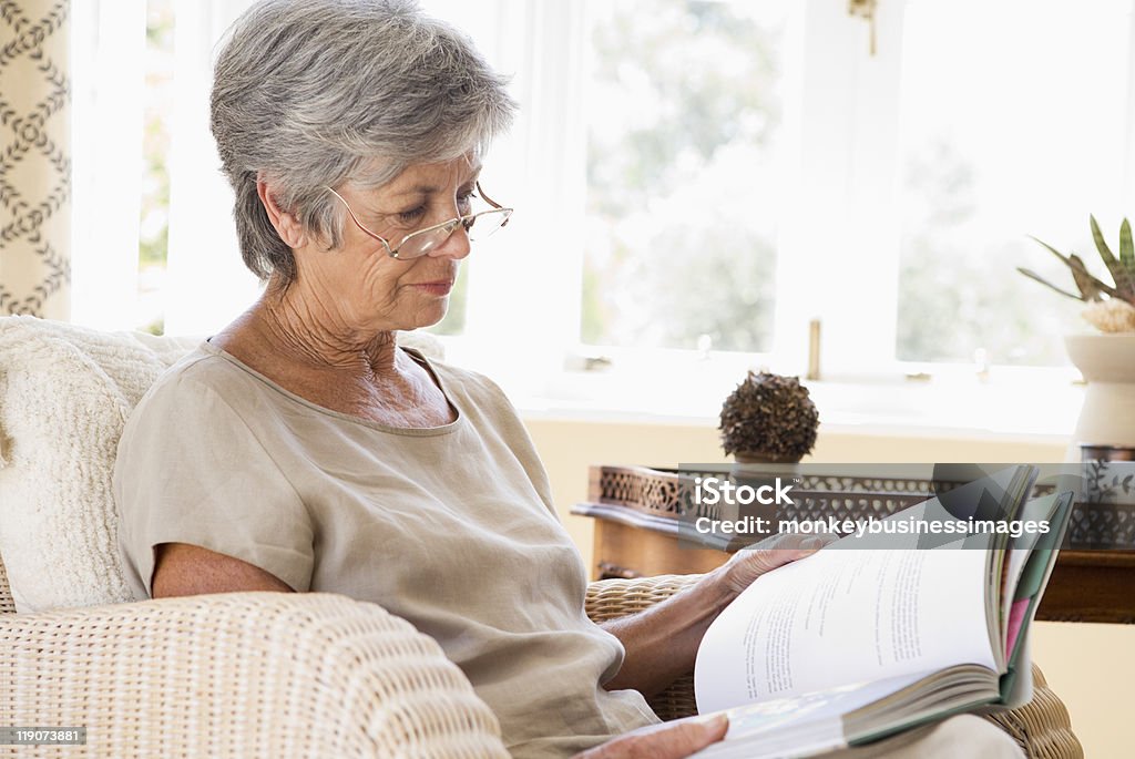 Женщина в гостиной, чтения к�ниги - Стоковые фото Читать роялти-фри