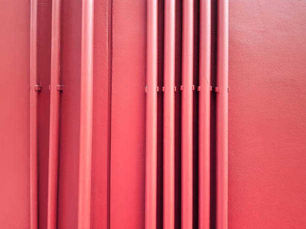 istock Rows of Vertical Red Pipes on Red Wall 1190754290