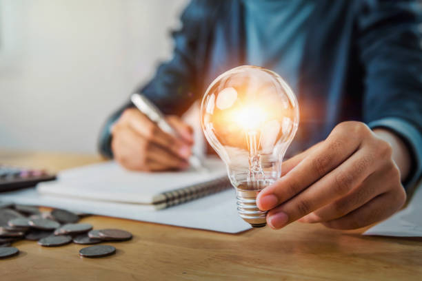 istock concept save energy power. businesswoman holding light bulb 1190762367