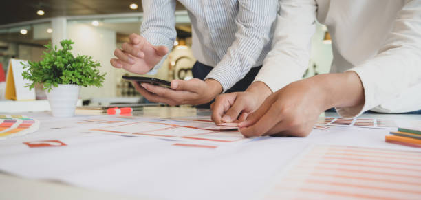 istock Close-up view of professional UI web developer team working on smartphone template together 1190769334