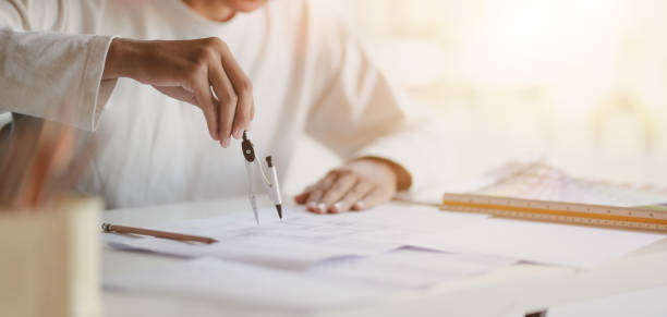 istock Close-up view of young professional architect working on working on construction plans in modern office 1190769949