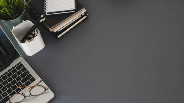 istock Top view of modern workplace with laptop computer and office supplies on dark table 1190770000