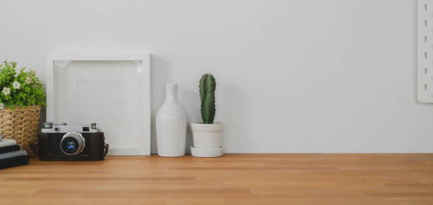 istock Cropped shot of comfortable office room with mock up frame, decorations and copy space on wooden table and white wall 1190770019