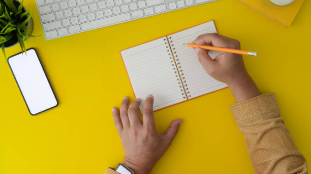 istock Top view of man working on his project by writing on notebook in trendy workplace 1190770062