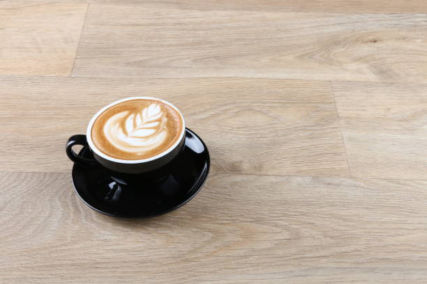 istock latte art foam - Coffee in a black cup 1190770585