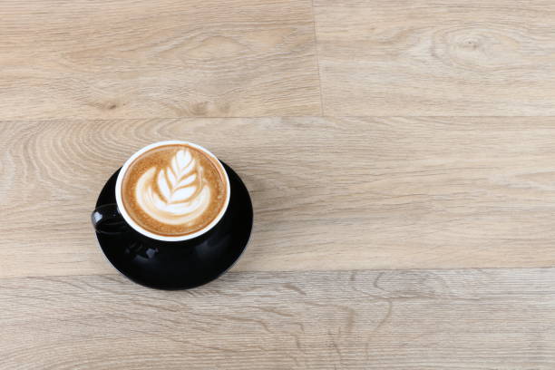 istock latte art foam - Coffee in a black cup 1190770589