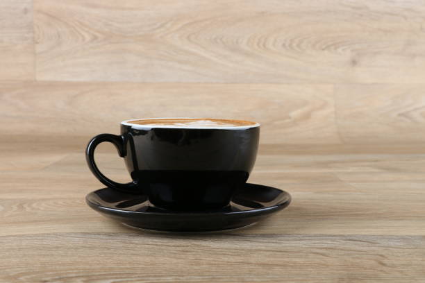 istock latte art foam - Coffee in a black cup 1190770623