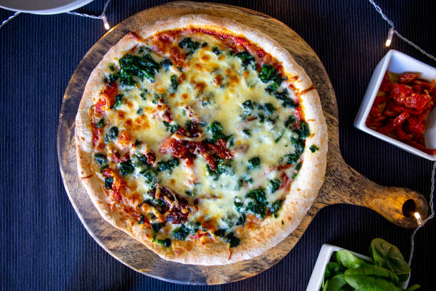 istock Spinach with dried tomateos and mzzarella cheese on pizza 1190773201
