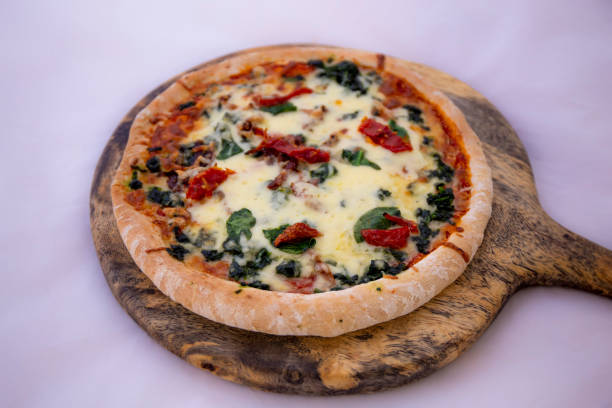 istock Spinach with dried tomateos and mzzarella cheese on pizza 1190773251
