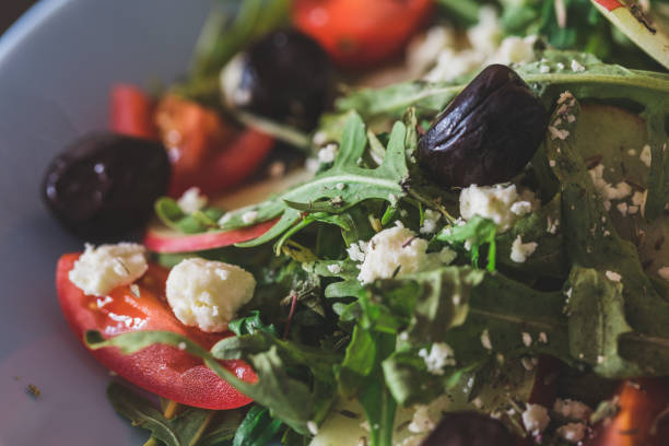 istock Arugula salad with fresh cheese, fresh apples, black olives and red cherry tomato on rustic background 1190774442