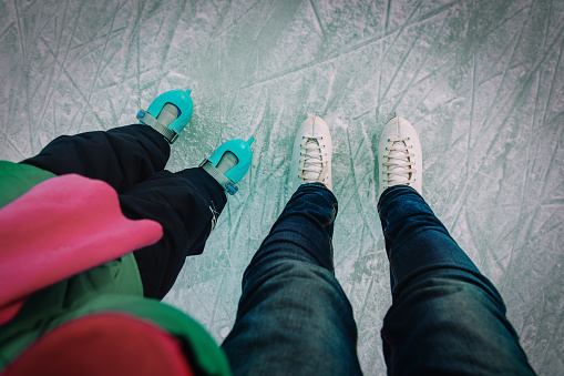 mother and child skating together in winter nature