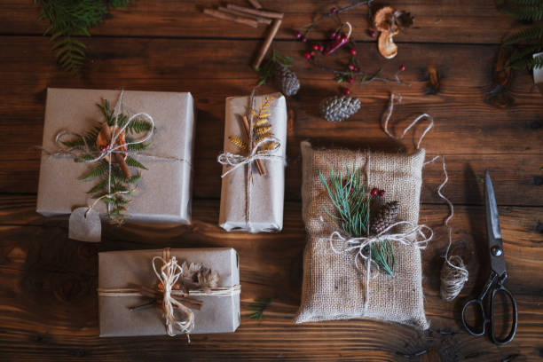 Preparing Christmas Gifts. Unrecognizable male hands wrapping Christmas presents with natural materials, plastic free, organic wrapping with paper. gift lounge stock pictures, royalty-free photos & images