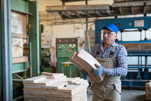 istock Manual worker holding timber plank in factory. 1190777595