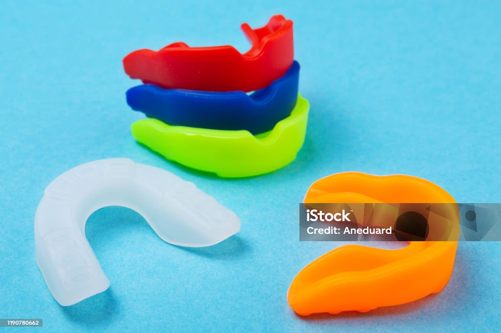 many colored boxing mouth guards lie on a blue background, concept many colored boxing mouth guards lie on a blue background, sports concept Mouthguard Stock Photo