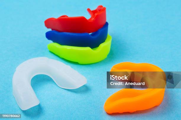 Many Colored Boxing Mouth Guards Lie On A Blue Background Concept Stock Photo - Download Image Now