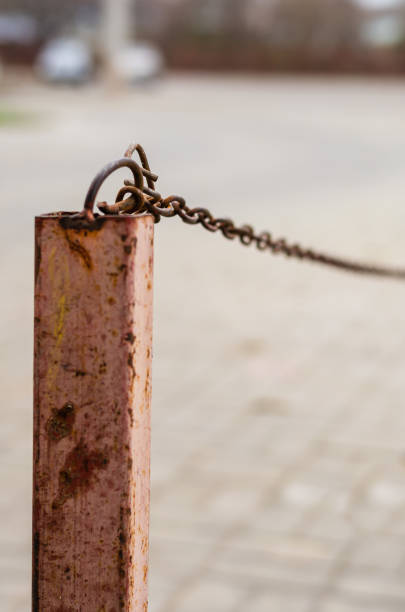 istock An old iron pole with a chain attached to it. 1190780785