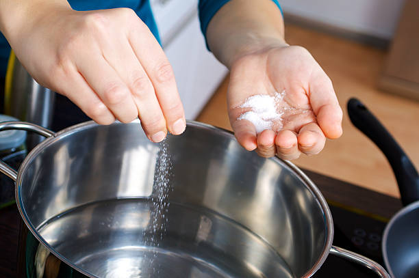 istock A hand putting some salt into a pot of water 119078257