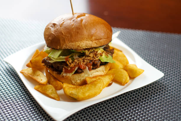 istock Meaty hamburger and fries on a table 1190790502
