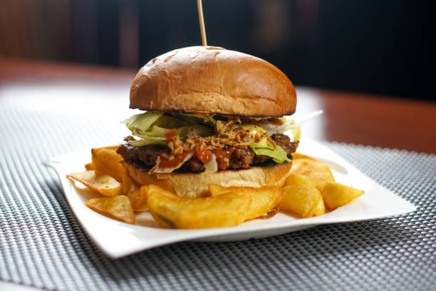 istock Meaty hamburger and fries on a table 1190790508