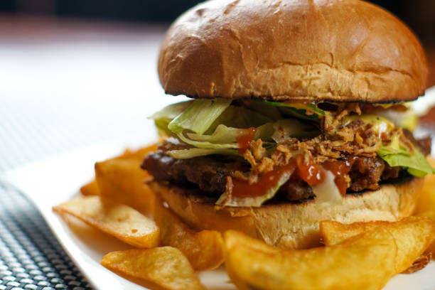 istock Meaty hamburger and fries on a table 1190790565