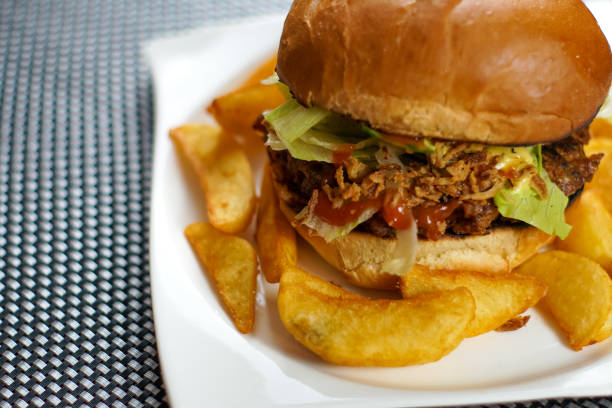 istock Meaty hamburger and fries on a table 1190790698