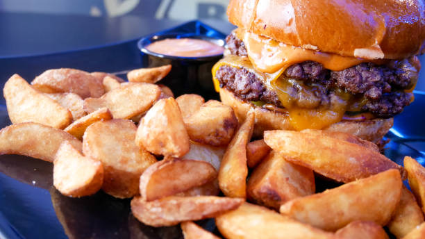 istock Meaty hamburger and fries on a table 1190791268