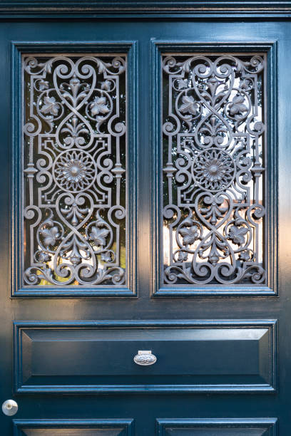 Wooden door with ornate window grate