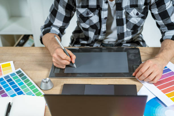 istock Young adult illustrator working with graphic tablet in office 1190798439