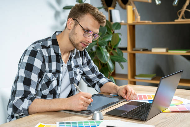istock Young adult man working with graphic tablet in office 1190798442